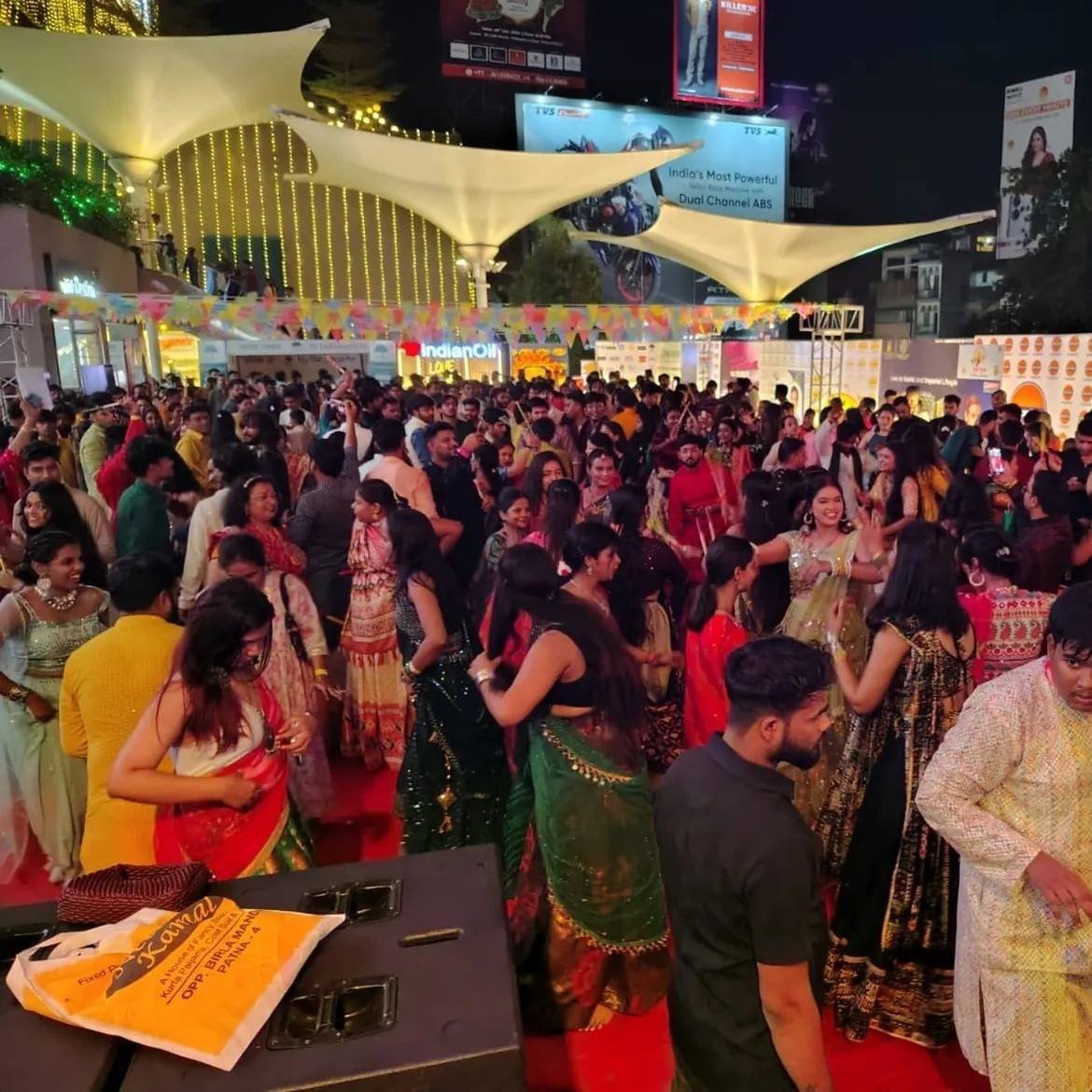 A packed Dandiya and Garba night under canopies and festive lights.