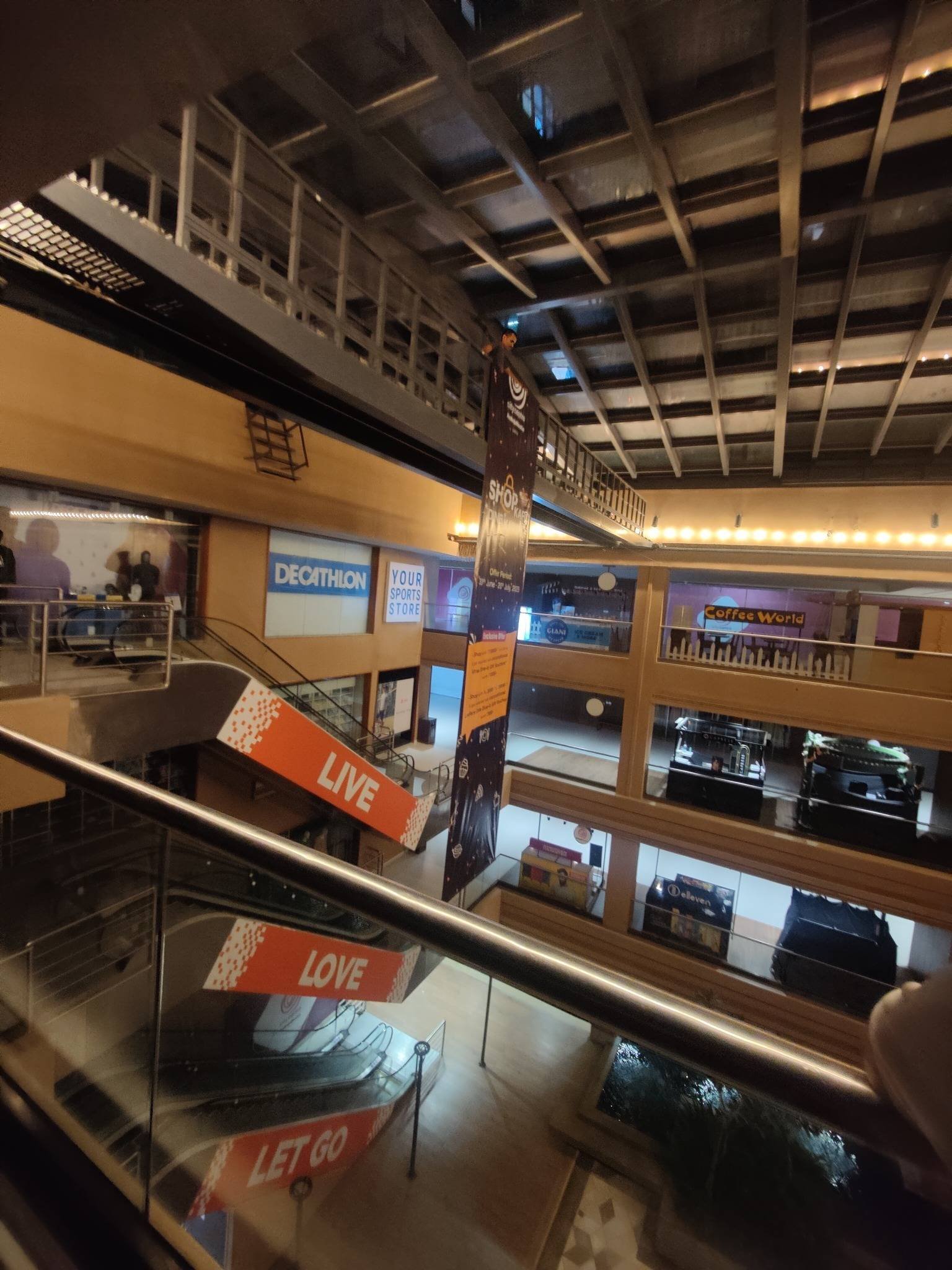 Drop-down banner installation hanging through a multi-level mall atrium.